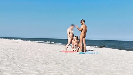 Два парня и девушка устроили групповой секс на нудистском пляже