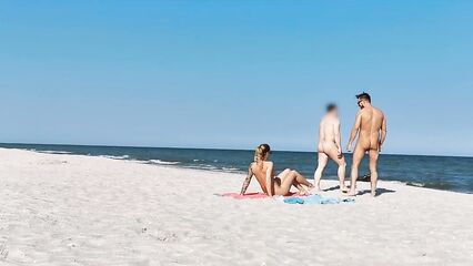 Два парня и девушка устроили групповой секс на нудистском пляже